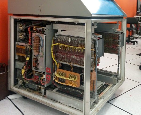Inside the IBM 1406 Storage Unit. At the left are the power supplies, including a 450W ferro-resonant regulator. The 8K core memory is at the right, connected by yellow wire bundles to the control circuitry above.