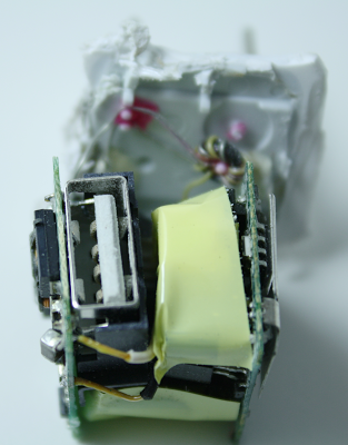 Inside the Apple iPhone charger. The two circuit boards and the USB jack are visible. The AC connection is at the back.