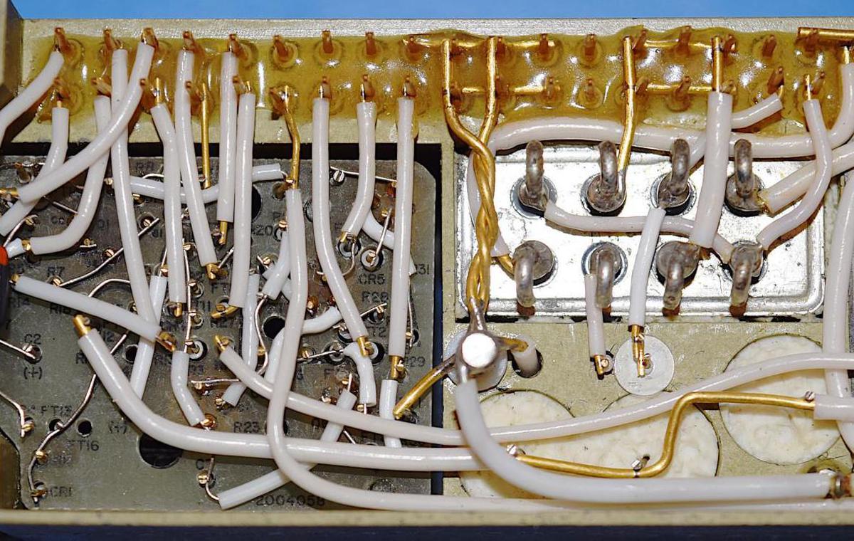 Cordwood construction in the power supply. On the left, components are mounted vertically through the module, 
with welded wiring on both sides. The metallic box on the right is a relay. Underneath the relay, the ends of filter capacitors are visible.