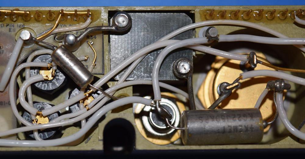 Closeup of transistors in the power supply.
The large transistor on the right is the high-current switching transistor.
Driving it required the three transistors on the left.