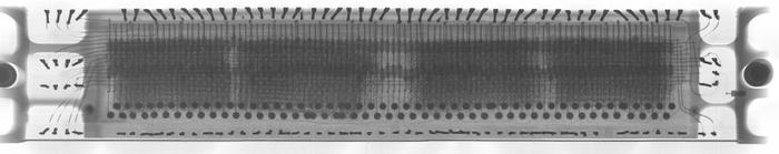 Composite X-ray image of the core memory module. The stitching isn't perfect in the image because the parallax and perspective changed in each image. In particular, the pins appear skewed in different directions.