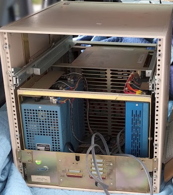 Looking into the back of the Alto, you can see the four switching power supplies (blue). The card cage is behind them. The disk drive has been removed from the top of the cabinet. On the back of the cabinet, connectors to the display, Ethernet, and other devices are visible.