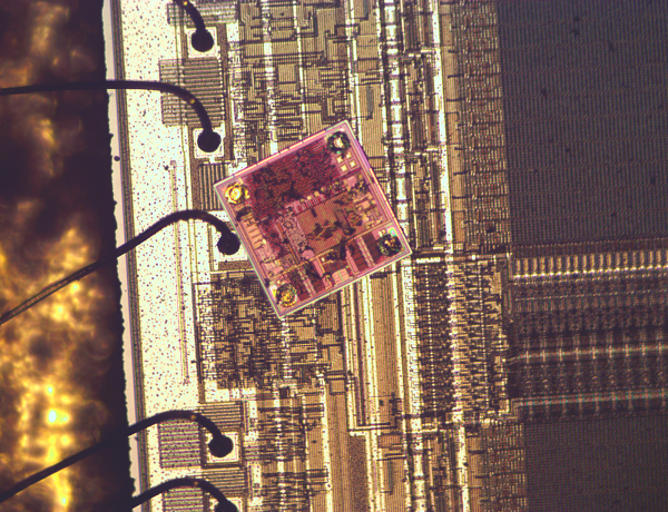 The Impinj Monza 4 RFID chip on top of a 8751 microcontroller chip shows that the RFID chip is very small and dense.
