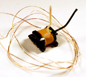 After removing the triple-stranded bias winding and insulating tape, the secondary winding of the transformer is visible. Note the triple-insulated wires used for the secondary winding.