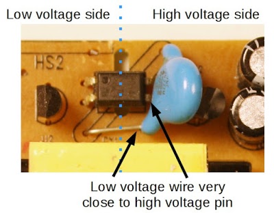 Safety hazard inside an imitation Macbook charger. The lead of the Y capacitor is too close to the pin of the optoisolator, causing a risk of shock.