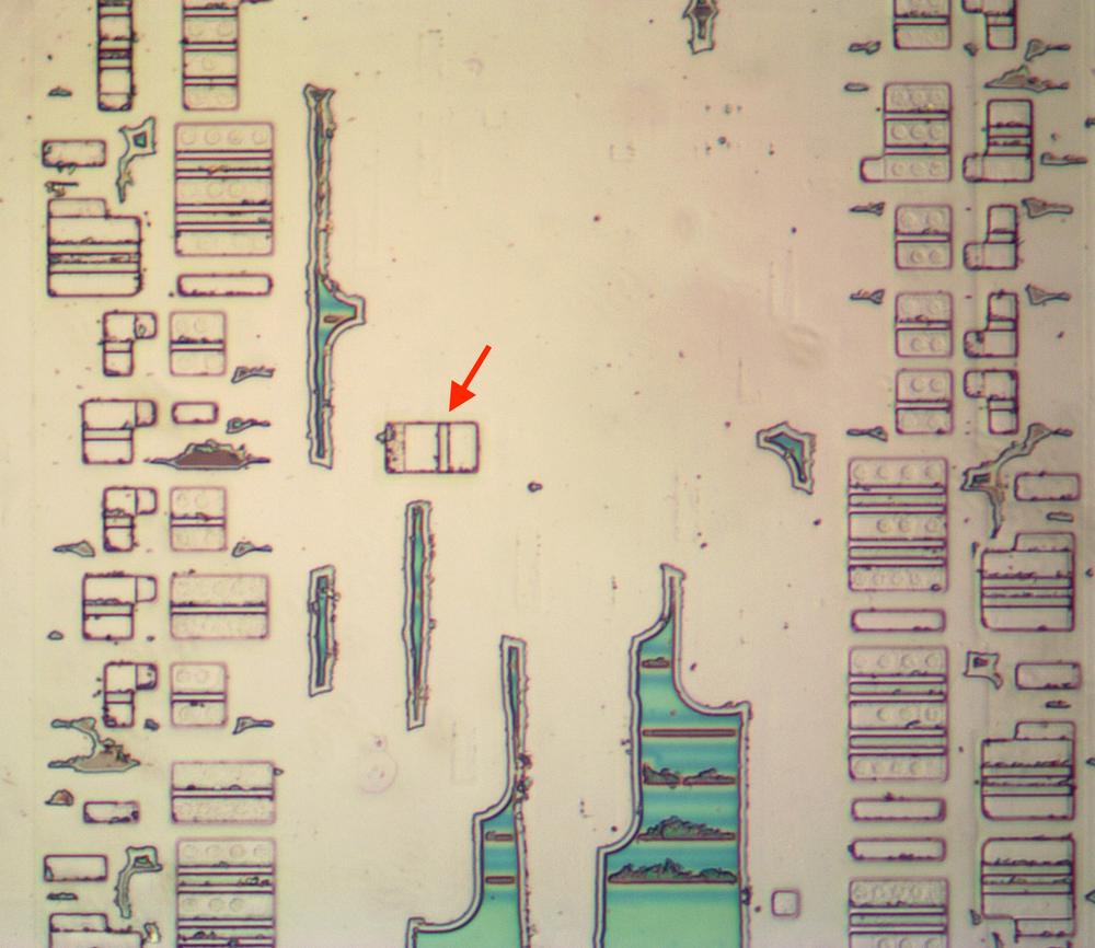 The "misplaced" transistor, indicated by the arrow. The irregular green regions are oxide that was incompletely removed. The "misplaced" transistor, indicated by the arrow. The irregular green regions are oxide that was incompletely removed.