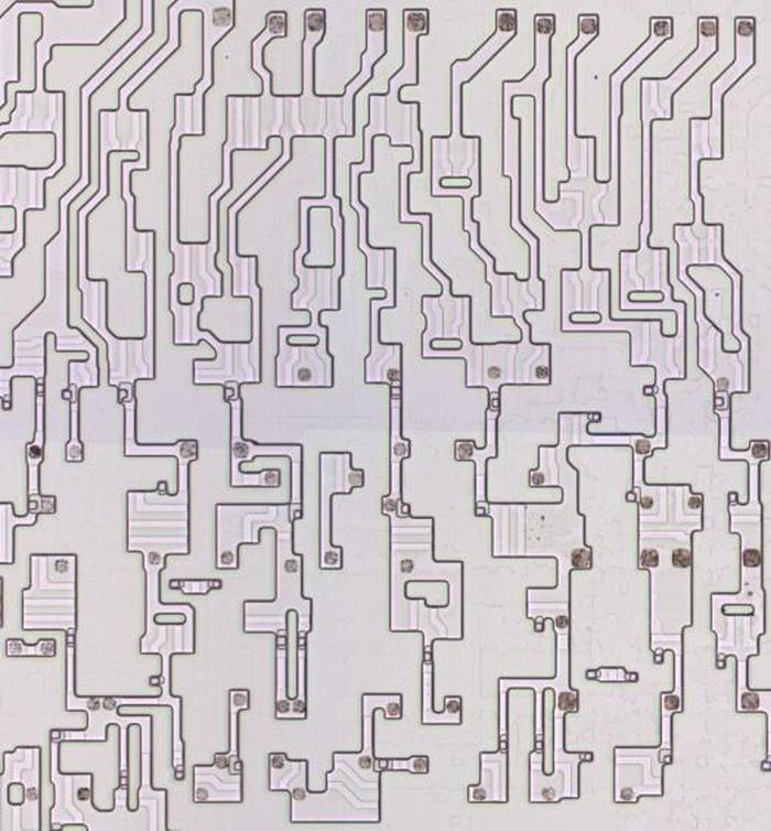 A closeup of transistors in the Zilog Z80 processor (1976). This chip is NMOS, not CMOS, which provides more layout flexibility. The metal and polysilicon layers have been removed to expose the underlying silicon. The lighter stripes over active silicon indicate where the polysilicon gates were. I think this photo is from the Visual 6502 project but I'm not sure.