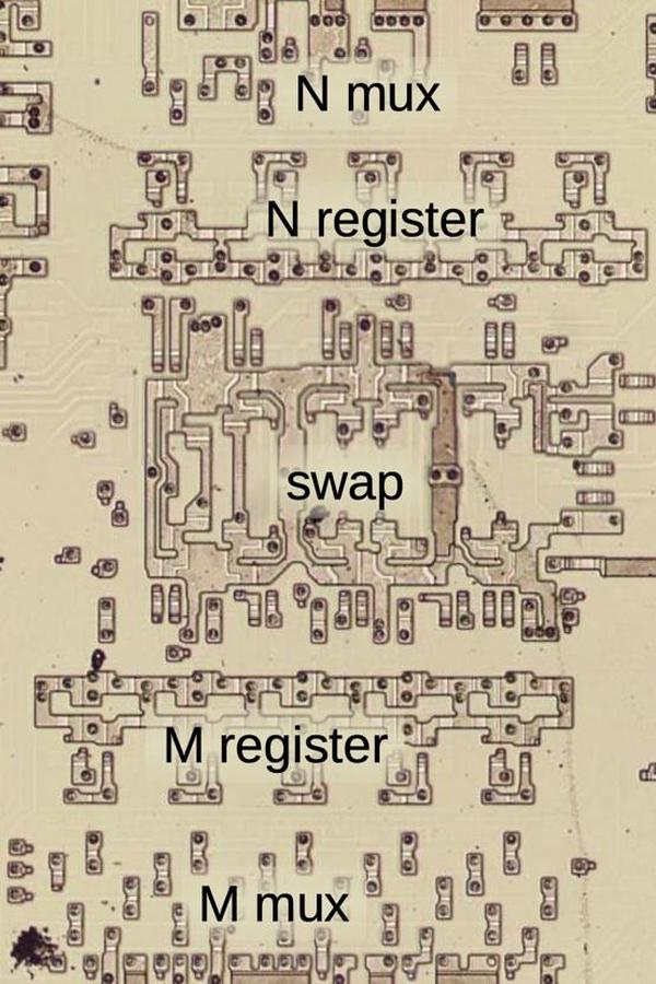 Die photo of the circuitry that implements the M and N registers. A multiplexer selects a source for the N register value and feeds it into the 5-bit N register. The M register is similar. Between the two registers is a "swap" circuit to swap the outputs of the two registers based on the instruction's "direction" bit. In this image, the metal layer has been dissolved with acid to show the transistors in the silicon layer underneath.