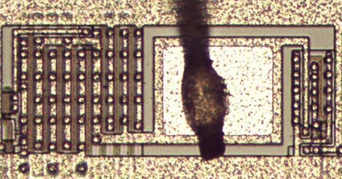 An output pad with a bond wire attached. Driver transistors next to the pad are constructed from multiple transistors in parallel.