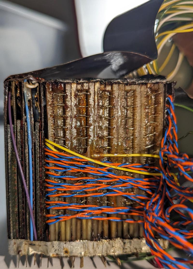 A closeup of the core memory stack. Brightly colored wires connect the module to the rest of the system. Small wires connect the layers together. 