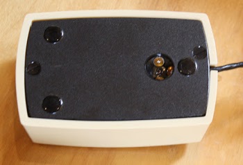 Underside of the mouse. The sensor (right) consists of three illumination LEDs surrounding the optical sensor.