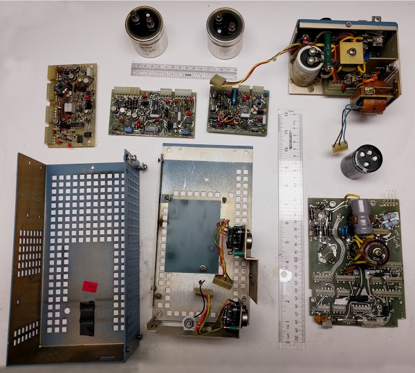 The Alto's switching power supply, disassembled. The main board is in the lower right. The three circuit boards are at top, below the large input capacitors.