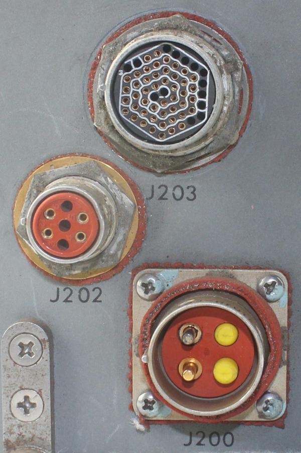 The unit has three connectors. The unit receives parallel data from ground equipment through the 61-pin connector at the top. The middle connector communicates the serial data to the Apollo Guidance Computer. The unit is powered with 28 volts through the bottom connector, which has larger pins for the high-current supply. 