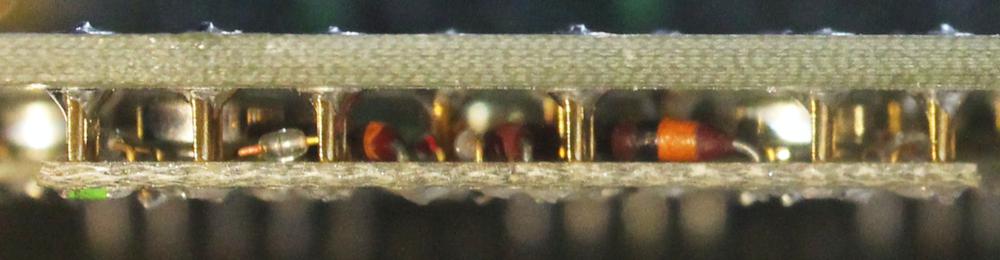 This side view shows a latch module (bottom) attached to the circuit board (top). The diodes, resistors, and transistors of the latch module are visible.