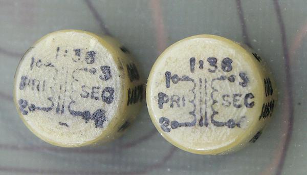 Two pulse transformers on the top circuit board. Each small transformer is about 1 cm in diameter.