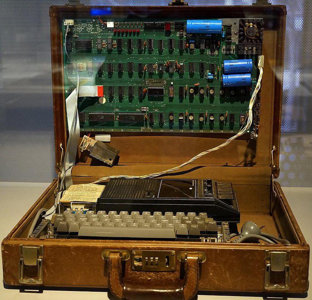 
The Apple-1 was sold as a bare board, so users needed to make a case for it, or mount it in a briefcase as shown here.
Note the cassette drive used for mass storage.
Photo cropped from Binarysequence, CC BY-SA 4.0.