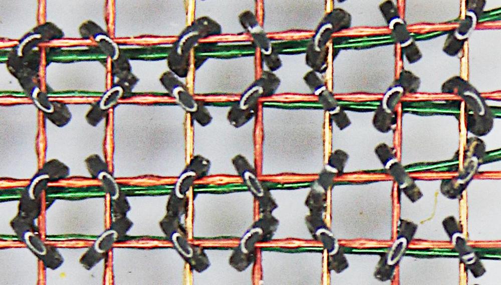 Closeup of an IBM 360 Model 50 core plane. The cores in this computer were called 19-32 because their inner diameter was 19 mils and their outer diameter was 32 mils (0.8 mm).