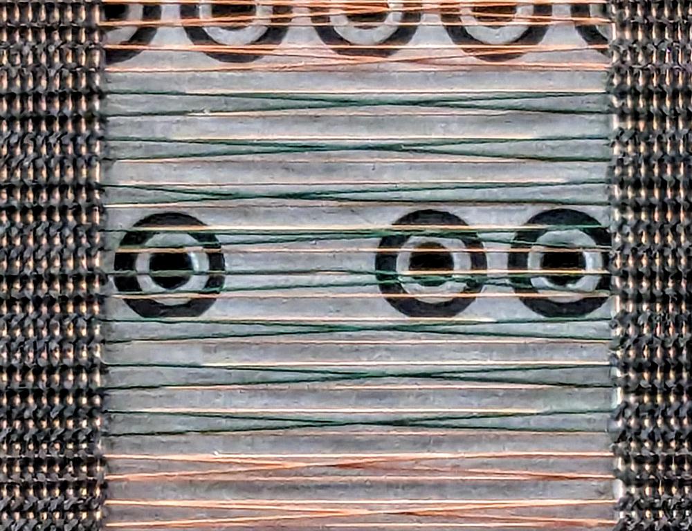 A close-up of the sense lines. The 16 sense lines in the middle are green, while the sense lines above and below (as well as the X lines) are copper. Note that the sense lines cross, while the X lines continue horizontally. The large circles are vias through the board.