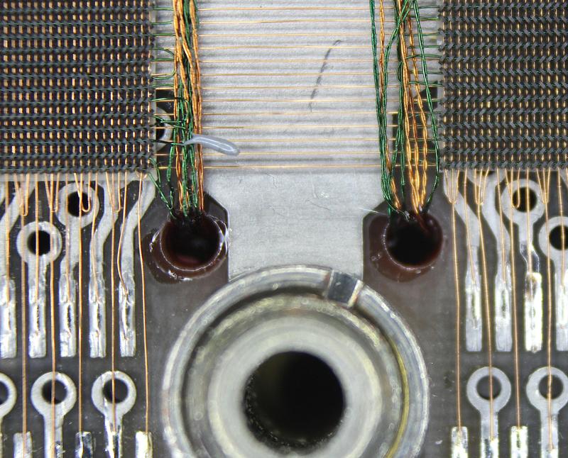 Each sense wire loop forms a twisted pair that is fed to the other side through a hole in the circuit board. Above the hole, you can see a gray blob where
sense wires were spliced for some reason.
Also note how alternating vertical wires are soldered to the
circuit board, with circular vias connected to the other side. The other vertical wires form loops.
are soldered to the circuit board
