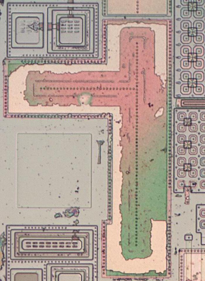 A capacitor on the die. The large faint square to the left of the capacitor is a pad for connecting a bond wire to the IC.
The complex structures on the left are clamp diodes on the pins. The cloverleaf structures on the right are transistors, which will
be discussed later.