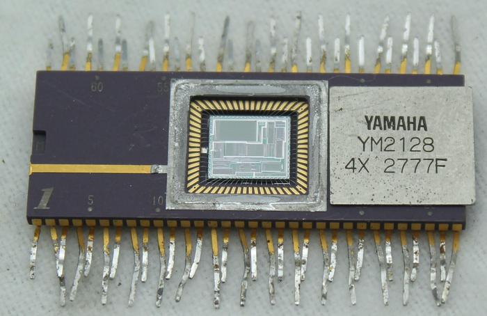 The Yamaha YM21280 OPS integrated circuit package with the metal lid removed, revealing the silicon die.