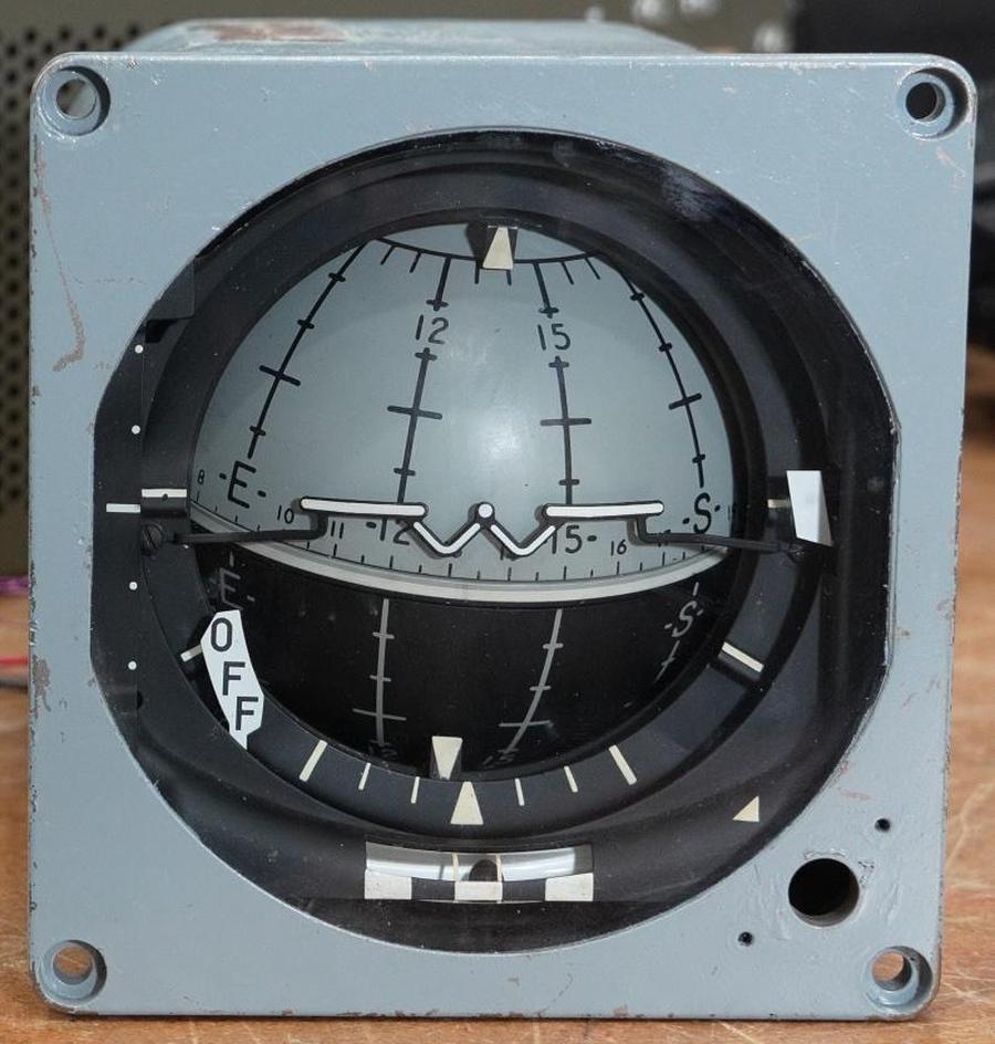 The attitude indicator. The "W" forms a stylized aircraft. In this case, it indicates that the aircraft is climbing slightly. Photo from CuriousMarc.