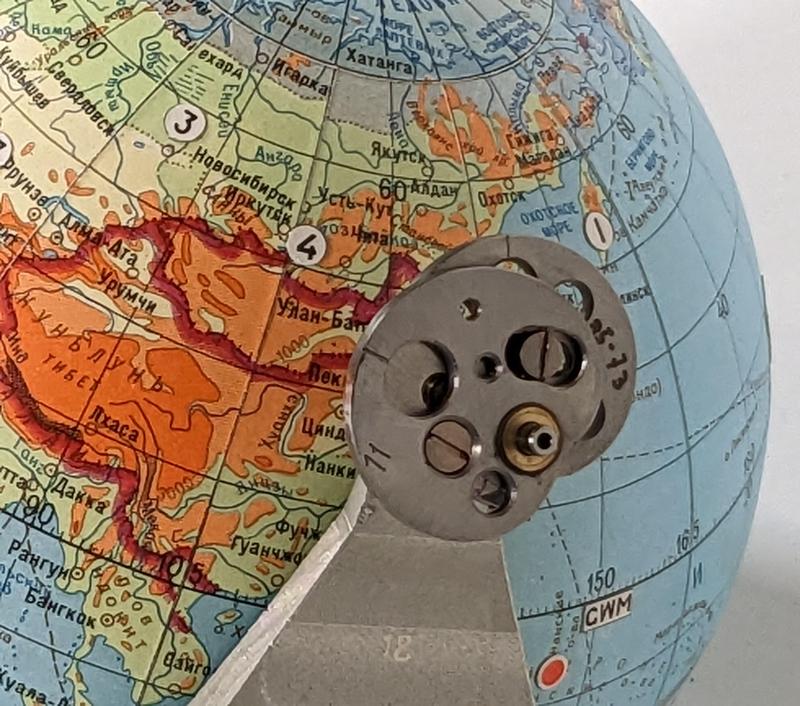 A cam is attached to the globe and rotates with the globe.