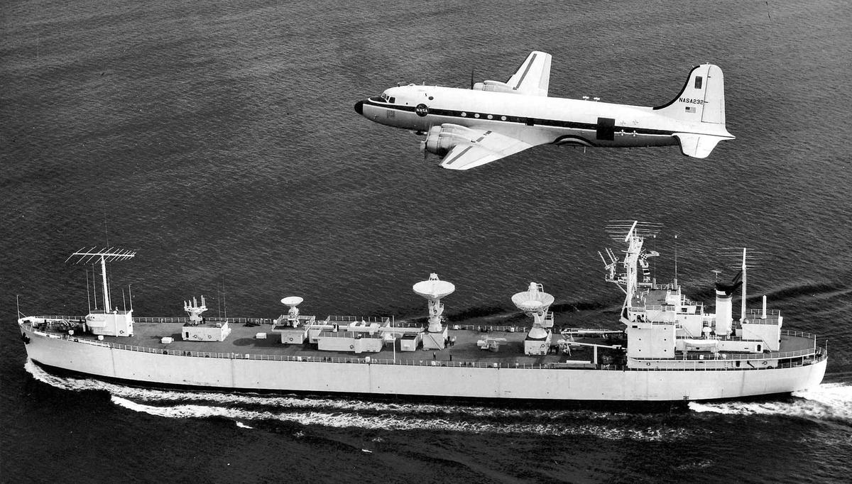 The USNS Vanguard with a NASA C-54 plane overhead. (source).