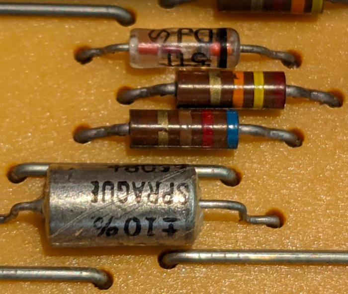The diode (striped glass cylinder), resistors (brown striped components), and capacitor (larger metal cylinder) create the delay.