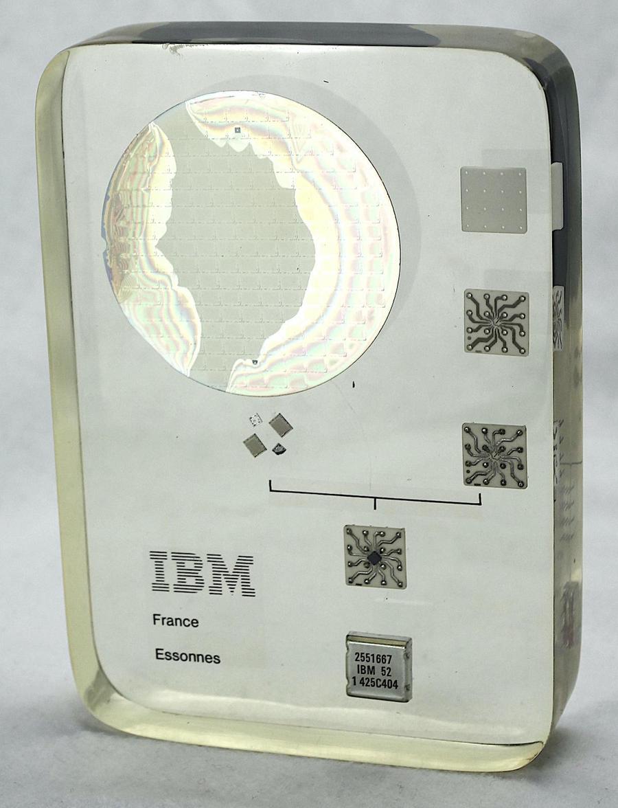 The paperweight contains a silicon wafer, four dies, and an MST module in various stages of assembly. The paperweight is somewhat yellowed with age. Click this image, or any other, for a larger photo.