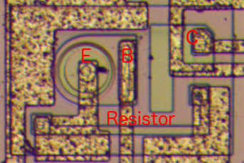 This image shows one of the superbeta transistors in the LM308 op amp. Note the large, round emitter. The green rectangle below the transistor is a resistor.