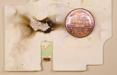 Burn marks inside an Apple Macbook charger that malfunctioned.