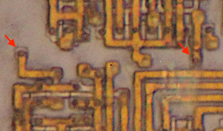 Closeup of the Pentium die showing the silicon and bottom metal layer. The arrows indicate connections to two antenna diodes. I removed the top two layers of metal for this photo.